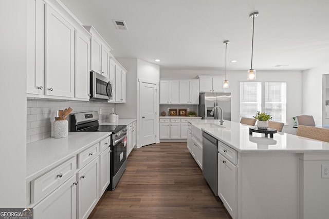 1313 Pj E Rd, Covington, GA 30014 - kitchen with appliances with stainless steel finishes, white cabinetry, dark wood-style flooring, an island with sink, and recessed lighting