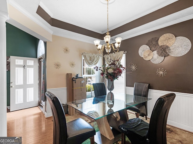 141 Wexford Ct, Stockbridge, GA 30281 - dining room featuring a wainscoted wall, a chandelier, crown molding, wood finished floors, and ornate columns