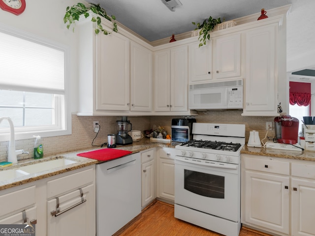141 Wexford Ct, Stockbridge, GA 30281 - kitchen featuring white appliances, backsplash, healthy amount of natural light, and white cabinetry