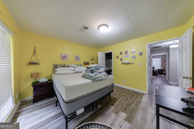 105 N River Dr Unit G, Sandy Springs, GA 30350 - bedroom featuring wood finished floors, multiple windows, and a textured ceiling