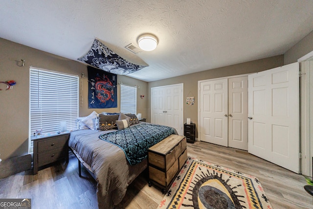 105 N River Dr Unit G, Sandy Springs, GA 30350 - bedroom with multiple closets, light wood finished floors, and a textured ceiling