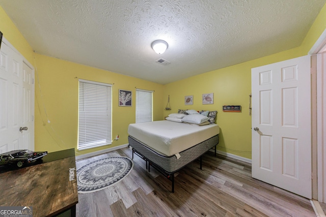105 N River Dr Unit G, Sandy Springs, GA 30350 - bedroom with wood finished floors and a textured ceiling
