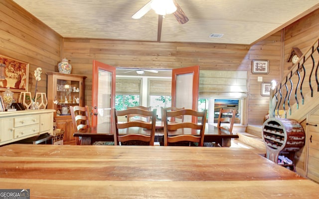 460 Morgan Mill Rd, Brooks, GA 30205 - dining area featuring a ceiling fan, wooden walls, healthy amount of natural light, and stairs