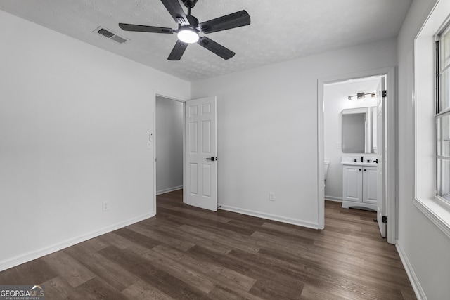 2800 Vultee Dr, Columbus, GA 31909 - unfurnished bedroom featuring dark wood finished floors, ensuite bath, a textured ceiling, and a ceiling fan