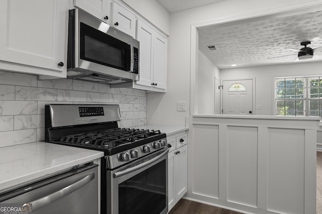 2800 Vultee Dr, Columbus, GA 31909 - kitchen featuring appliances with stainless steel finishes, white cabinetry, ceiling fan, and backsplash