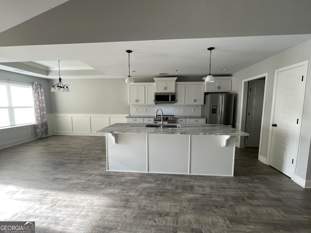 113 Sourwood Ln, Warner Robins, GA 31093 - kitchen with appliances with stainless steel finishes, a kitchen island with sink, white cabinetry, light stone counters, and dark wood-style flooring