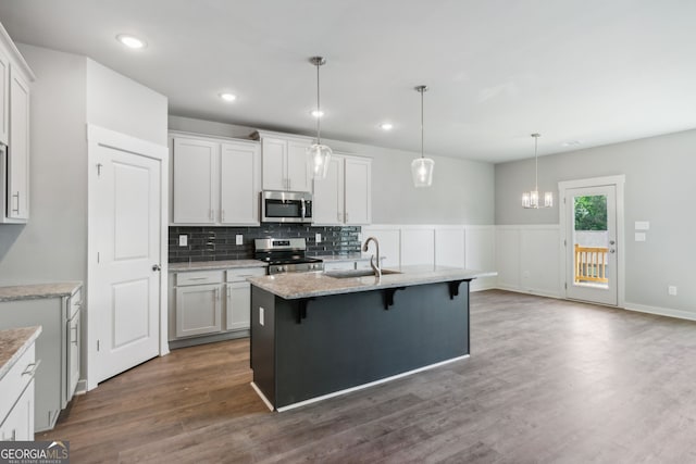 4601 Blacksmith Ln, Jefferson, GA 30549 - kitchen with stainless steel appliances, a kitchen bar, dark wood-style floors, backsplash, and hanging light fixtures