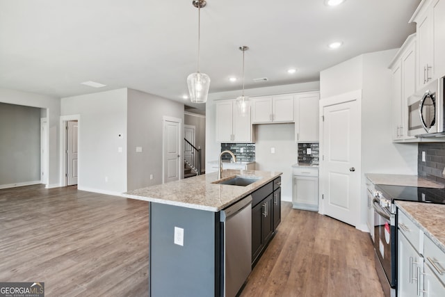 4601 Blacksmith Ln, Jefferson, GA 30549 - kitchen with appliances with stainless steel finishes, light wood finished floors, tasteful backsplash, white cabinetry, and recessed lighting