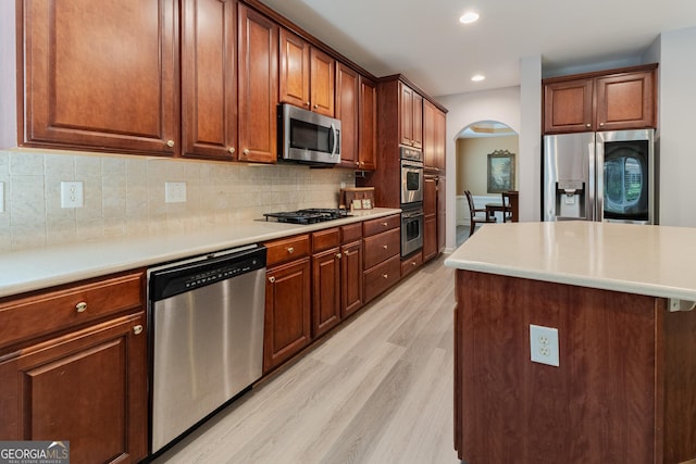 2940 Bentbill Xing, Cumming, GA 30041 - kitchen with stainless steel appliances, arched walkways, light wood-type flooring, tasteful backsplash, and recessed lighting