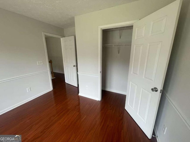 2994 Abbotts Oak Way, Duluth, GA 30097 - unfurnished bedroom with wood finished floors, a closet, and a textured ceiling