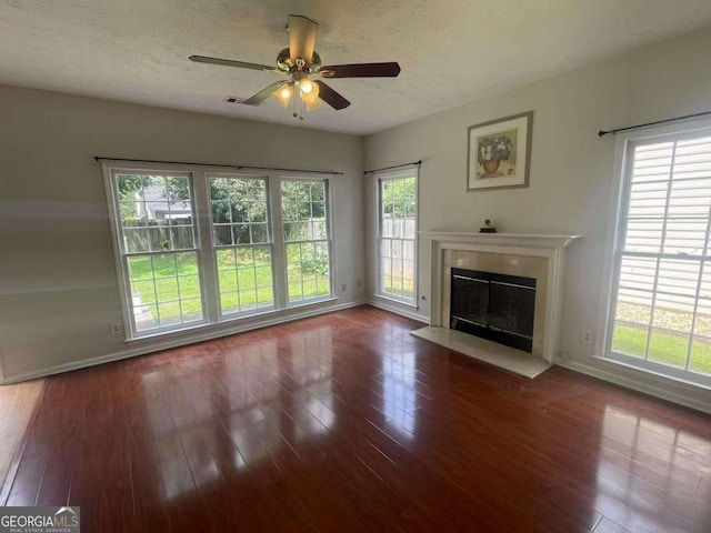 2994 Abbotts Oak Way, Duluth, GA 30097 - unfurnished living room with wood-type flooring, a glass covered fireplace, ceiling fan, healthy amount of natural light, and a textured ceiling