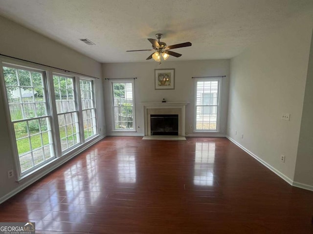 2994 Abbotts Oak Way, Duluth, GA 30097 - unfurnished living room with plenty of natural light, a ceiling fan, a fireplace with flush hearth, dark wood-style flooring, and a textured ceiling