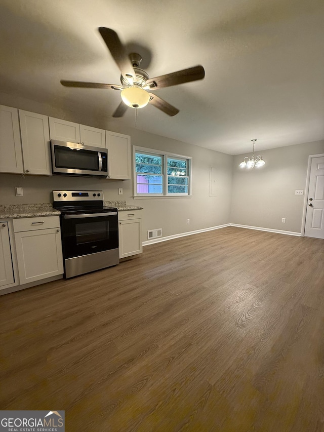 882 Campbell Rd, Covington, GA 30014 - kitchen with appliances with stainless steel finishes, dark wood-style floors, white cabinetry, ceiling fan, and a chandelier