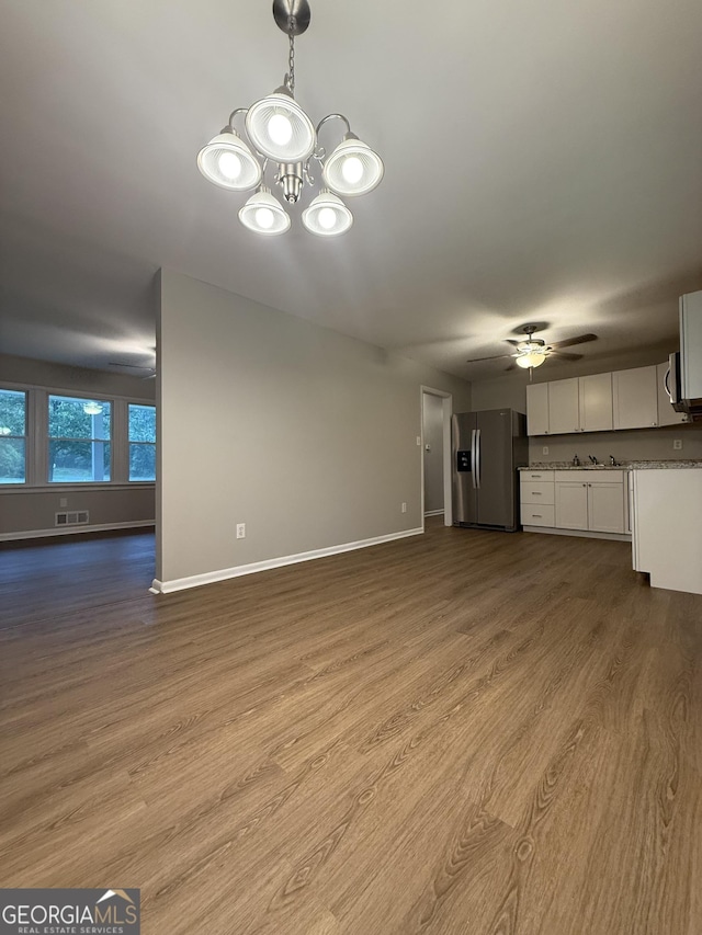 882 Campbell Rd, Covington, GA 30014 - unfurnished living room with wood finished floors, a ceiling fan, and a chandelier