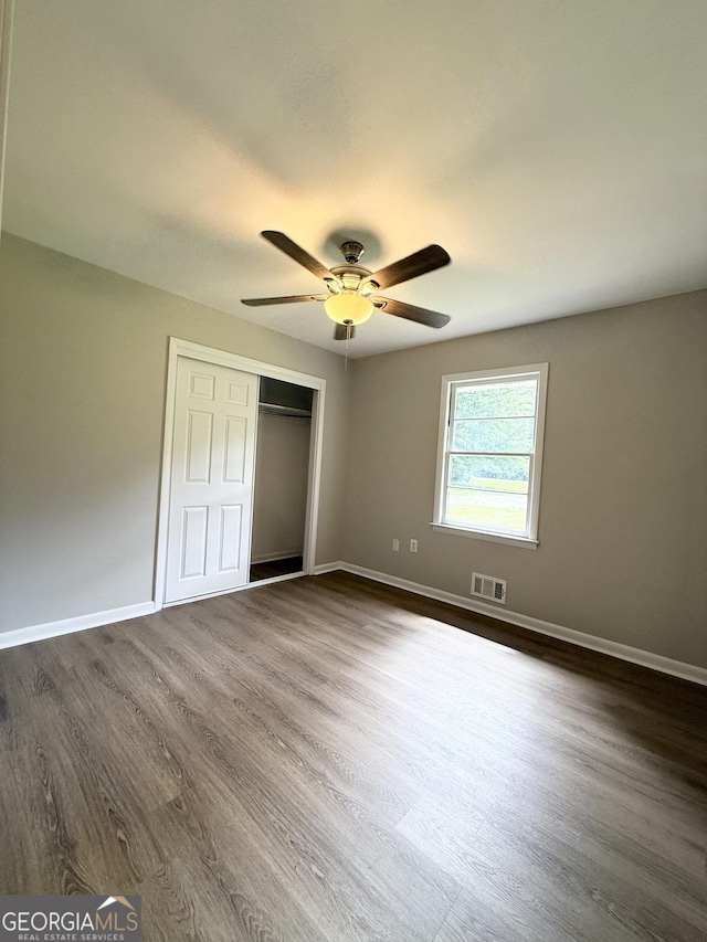 882 Campbell Rd, Covington, GA 30014 - unfurnished bedroom featuring dark wood finished floors, a closet, and a ceiling fan