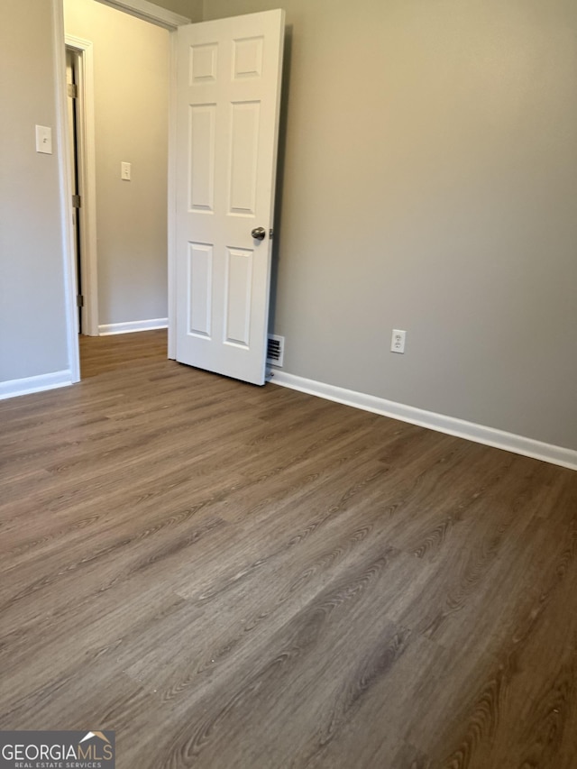 882 Campbell Rd, Covington, GA 30014 - unfurnished bedroom with baseboards and dark wood-style flooring