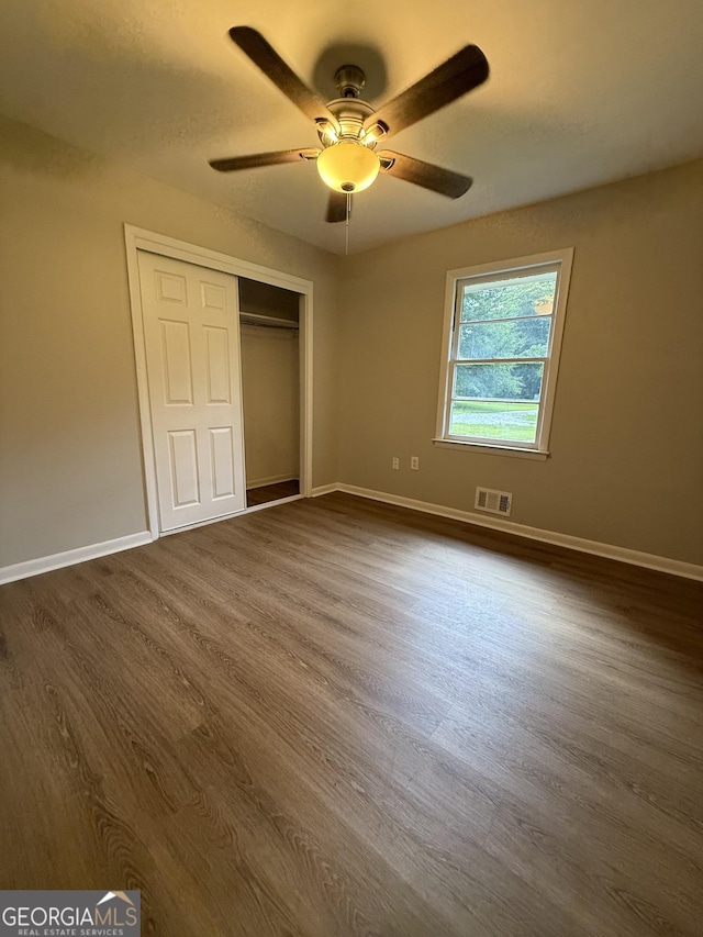 882 Campbell Rd, Covington, GA 30014 - unfurnished bedroom with dark wood finished floors, a closet, and a ceiling fan