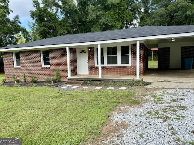 882 Campbell Rd, Covington, GA 30014 - ranch-style house featuring gravel driveway, brick siding, a front yard, a carport, and covered porch