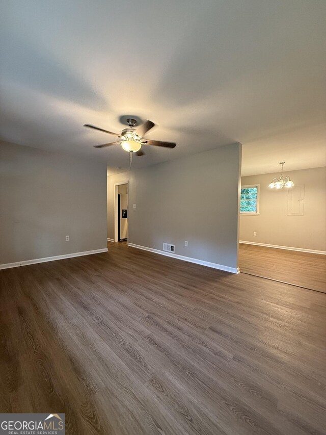 882 Campbell Rd, Covington, GA 30014 - empty room featuring dark wood-style flooring, ceiling fan, and a chandelier