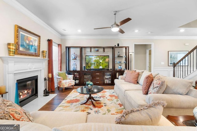 850 Ethereow Ct, Lawrenceville, GA 30046 - living area featuring dark wood finished floors, ornamental molding, a ceiling fan, stairs, and a glass covered fireplace