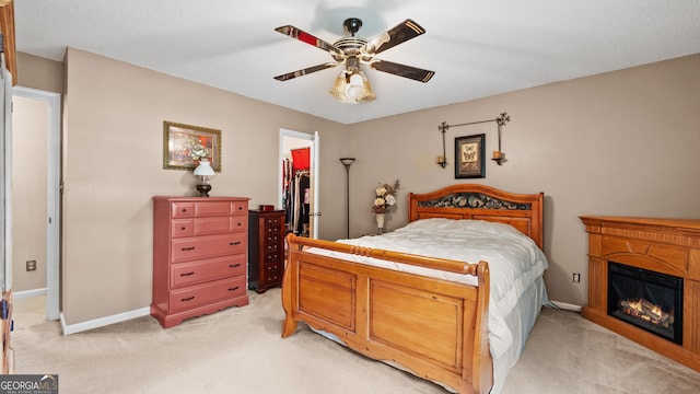 3627 Spring Meadow Ct, Acworth, GA 30101 - bedroom featuring light carpet, a walk in closet, a ceiling fan, and a glass covered fireplace