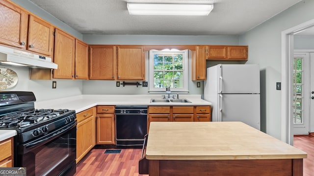3627 Spring Meadow Ct, Acworth, GA 30101 - kitchen featuring black appliances, under cabinet range hood, light wood-type flooring, light countertops, and a textured ceiling