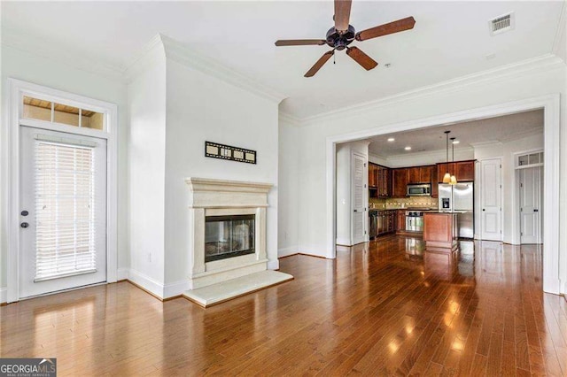 3635 E Paces Cir NE Unit 1405, Atlanta, GA 30326 - unfurnished living room featuring dark wood-style floors, a ceiling fan, ornamental molding, and a glass covered fireplace
