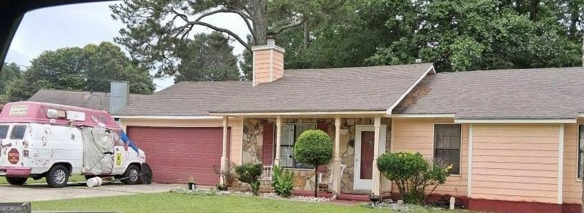 10359 Briarbay Loop, Jonesboro, GA 30238 - view of front of property featuring a chimney, a garage, and driveway