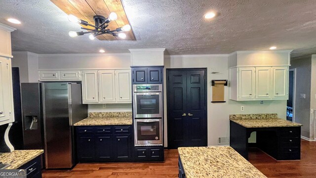 1310 Larkview Dr SW, Lilburn, GA 30047 - kitchen featuring appliances with stainless steel finishes, wood finished floors, a chandelier, light stone countertops, and a textured ceiling