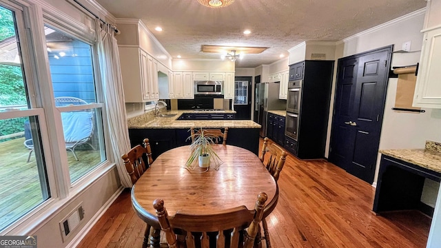 1310 Larkview Dr SW, Lilburn, GA 30047 - dining area featuring light wood-style floors, ornamental molding, healthy amount of natural light, recessed lighting, and a textured ceiling