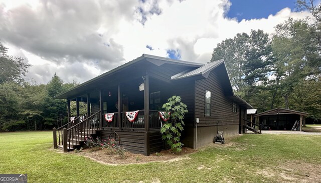 226 Cherokee Rd, Glenwood, GA 30428 - view of property exterior with a lawn, a porch, stairway, and a metal roof