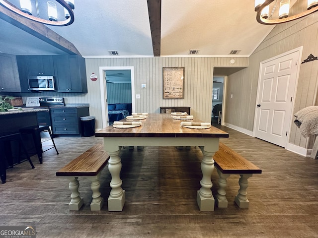 226 Cherokee Rd, Glenwood, GA 30428 - kitchen with stainless steel microwave, blue cabinets, wood finished floors, wooden walls, and a textured ceiling