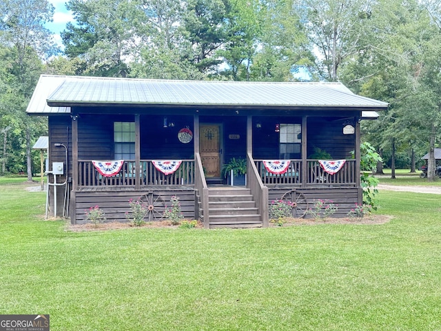 226 Cherokee Rd, Glenwood, GA 30428 - view of front of home with a porch, a front yard, a metal roof, and view of wooded area