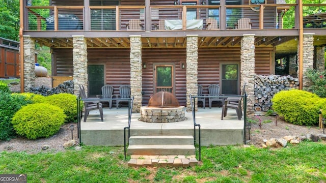 2357 Haven Heights Rd, Hiawassee, GA 30546 - rear view of house with a patio, an outdoor fire pit, faux log siding, and a balcony