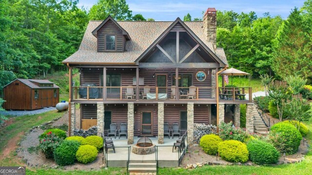 2357 Haven Heights Rd, Hiawassee, GA 30546 - view of front of home featuring an outdoor fire pit, a patio, a storage unit, faux log siding, and a chimney