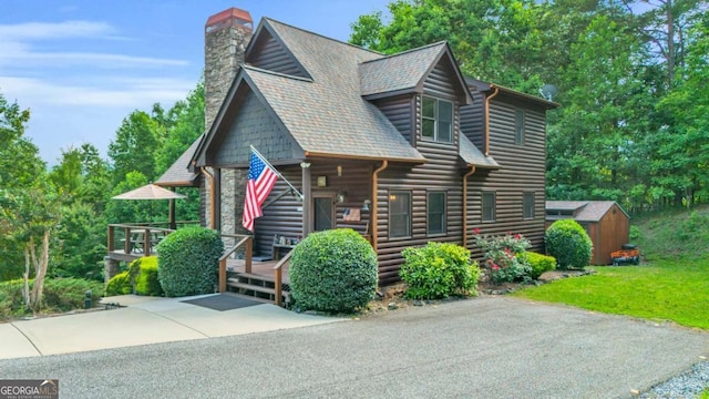 2357 Haven Heights Rd, Hiawassee, GA 30546 - view of front of home featuring log veneer siding, a chimney, and a storage shed