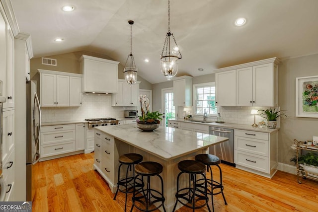 1060 Woodhollow Ln, Athens, GA 30606 - kitchen with appliances with stainless steel finishes, a kitchen island, a breakfast bar, a chandelier, and vaulted ceiling