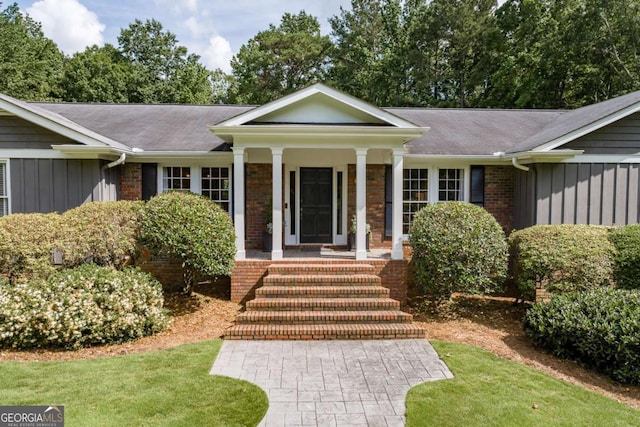 1060 Woodhollow Ln, Athens, GA 30606 - view of front facade featuring board and batten siding, a porch, and a front lawn