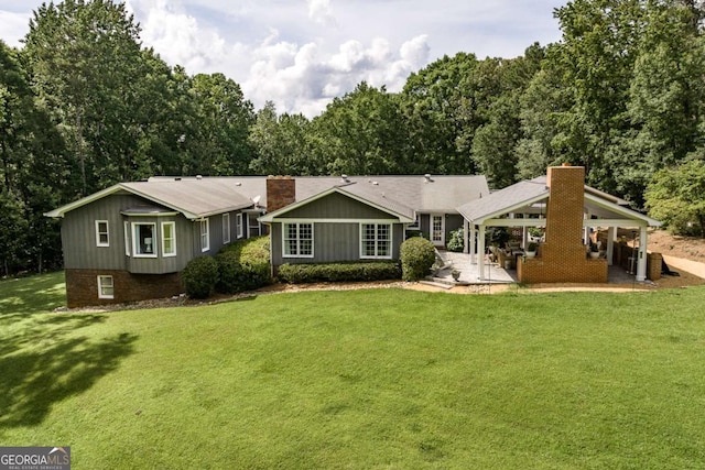 1060 Woodhollow Ln, Athens, GA 30606 - rear view of house featuring a chimney, a yard, a patio, and board and batten siding