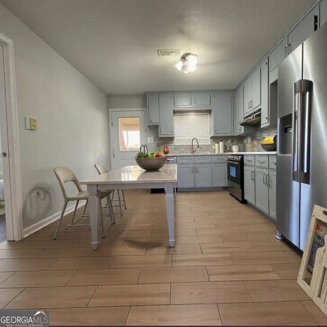 303 Latimer St, Marietta, GA 30008 - kitchen with stainless steel fridge with ice dispenser, gray cabinetry, wood tiled floors, light countertops, and tasteful backsplash
