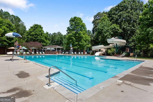 5007 Highland Oaks Ct SE, Smyrna, GA 30126 - community pool featuring a water slide, a patio area, and view of wooded area