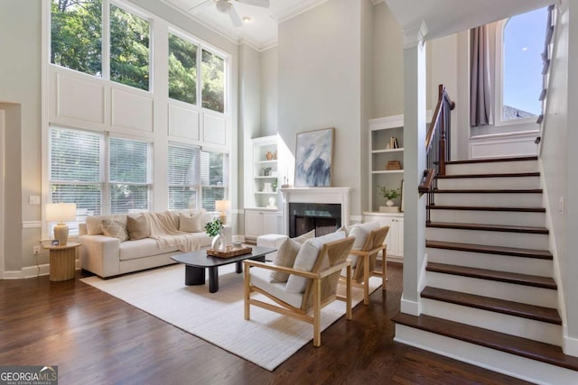 5007 Highland Oaks Ct SE, Smyrna, GA 30126 - living area featuring crown molding, a towering ceiling, a ceiling fan, a fireplace, and stairs