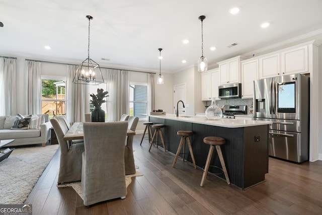 550 Azalea Xing, Dallas, GA 30132 - kitchen with appliances with stainless steel finishes, ornamental molding, a breakfast bar area, backsplash, and light countertops