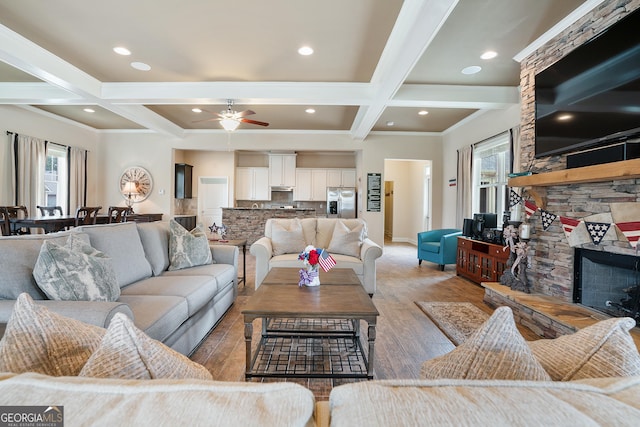 550 Azalea Xing, Dallas, GA 30132 - living room featuring coffered ceiling, a stone fireplace, light wood-type flooring, beam ceiling, and ceiling fan