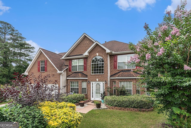 11961 Markham Way, Hampton, GA 30228 - traditional-style home with brick siding, a front yard, and a shingled roof