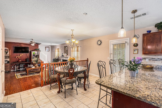 11961 Markham Way, Hampton, GA 30228 - dining space featuring a textured ceiling, ceiling fan, a chandelier, and light tile patterned floors