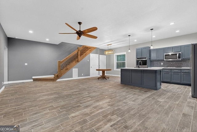 67 Mcnelley Dr, Morganton, GA 30560 - kitchen with appliances with stainless steel finishes, ceiling fan, light wood-style floors, backsplash, and light countertops
