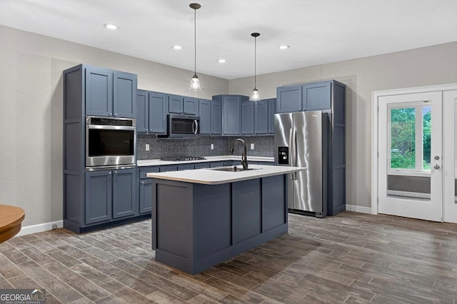 67 Mcnelley Dr, Morganton, GA 30560 - kitchen featuring stainless steel appliances, backsplash, light countertops, dark wood finished floors, and a center island with sink