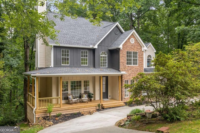 5560 Pilgrim Point Ext, Cumming, GA 30041 - view of front of home featuring board and batten siding, covered porch, a chimney, and roof with shingles