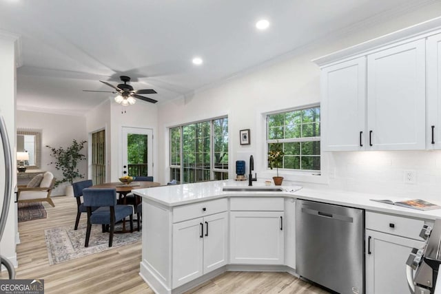 5560 Pilgrim Point Ext, Cumming, GA 30041 - kitchen with stainless steel dishwasher, light wood-style flooring, a peninsula, white cabinetry, and light countertops